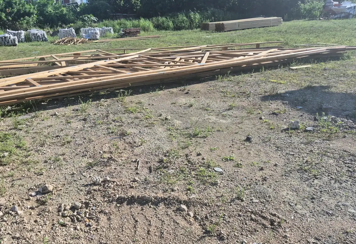 Manufactured roof trusses with steel connector plates staged in Overtime's Nassau yard